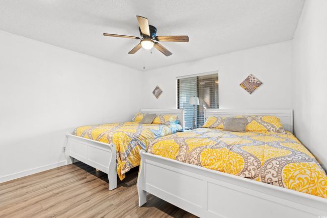Bedroom with wood finished floors and ceiling fan | Image 17