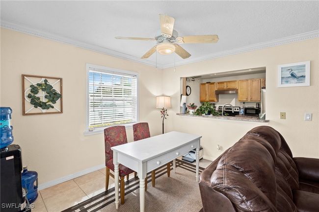 Dining area featuring light tile patterned flooring, baseboards, ceiling fan, and ornamental molding | Image 11