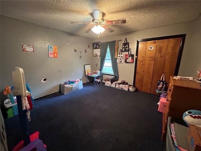 Playroom with a ceiling fan, carpet, and a textured ceiling | Image 19