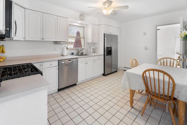 Kitchen with white cabinetry, sink, and stainless steel appliances | Image 11
