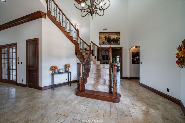 Entrance foyer featuring ornamental molding, a high ceiling, and a chandelier | Image 4