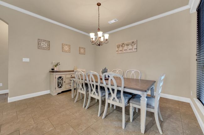 Dining space with a chandelier, crown molding, baseboards, and arched walkways | Image 10