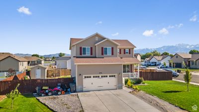 View of property featuring a front lawn, a garage, and a mountain view | Image 2