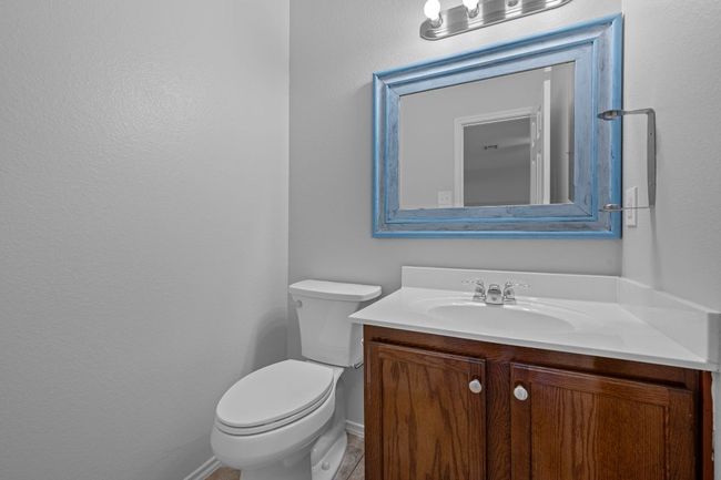 Half bathroom featuring vanity, toilet, and baseboards | Image 23