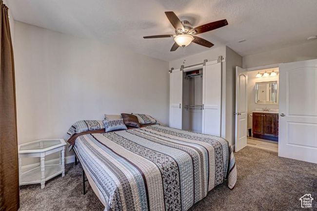 Bedroom featuring baseboards, carpet floors, ceiling fan, and a barn door | Image 23