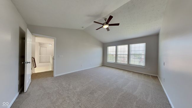 carpeted empty room with ceiling fan, lofted ceiling, and baseboards | Image 10