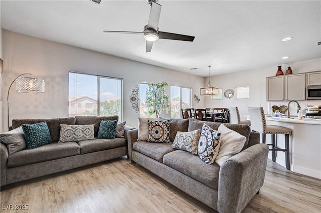 Living area featuring light wood-type flooring, a ceiling fan, a chandelier, and recessed lighting | Image 13