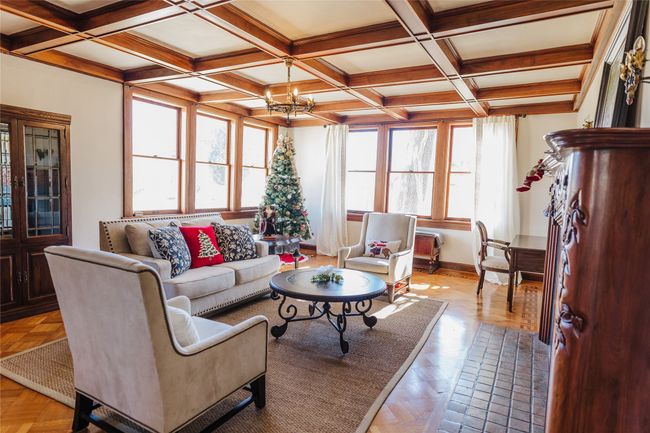 Living room with light parquet floors, a chandelier, beam ceiling, and coffered ceiling | Image 7