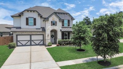 Experience stunning curb appeal with meticulously landscaped gardens and a grand entrance that welcomes you home. | Image 1