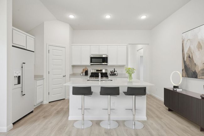 Kitchen featuring stainless steel appliances, light wood-type flooring, light countertops, white cabinetry, and recessed lighting | Image 5
