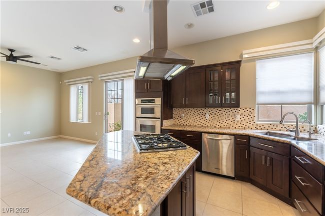 Kitchen with a sink, stainless steel appliances, island exhaust hood, and visible vents | Image 7