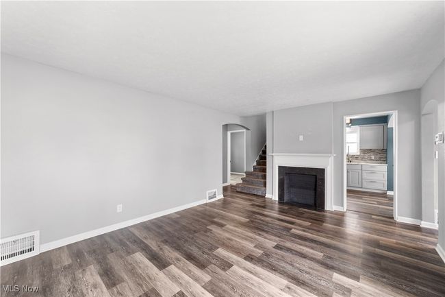 Living room with arched doorway to bedroom hallway | Image 7