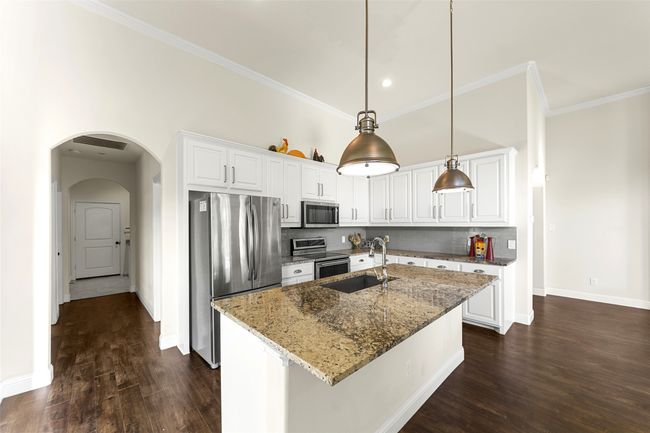 Another view of kitchen and back entry from garage with laundry room to the right down hallway. | Image 15