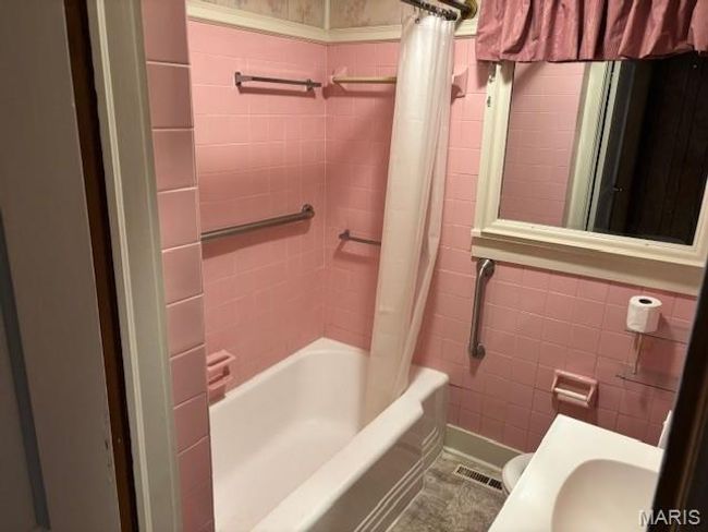 Full bath featuring tile walls, shower / bath combination with curtain, toilet, and vanity | Image 29