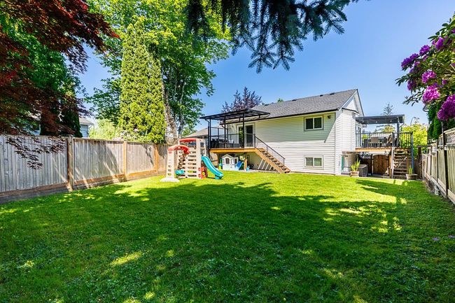 Back of house with stairway, a playground, and a wooden deck | Image 35