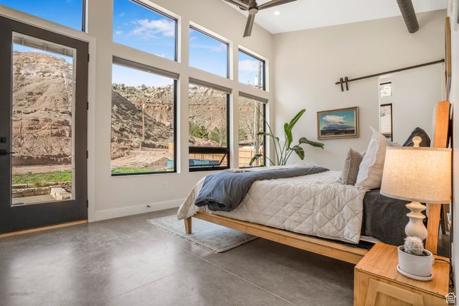 Bedroom with concrete flooring, a towering ceiling, recessed lighting, access to exterior, and baseboards | Image 19