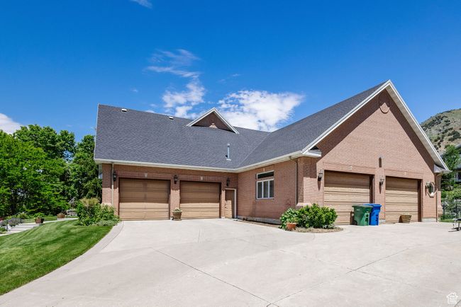 View of front facade with brick siding, a garage, driveway, and a front yard | Image 75
