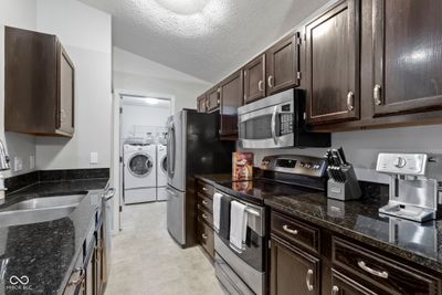 Beautifully updated kitchen with granite countertops, dark stained cabinets and stainless steel appliances. So many gourmet cooking nights you'll have! | Image 3