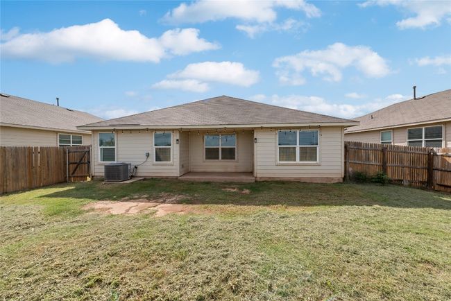 Back of property featuring a fenced backyard, a shingled roof, and a patio | Image 21