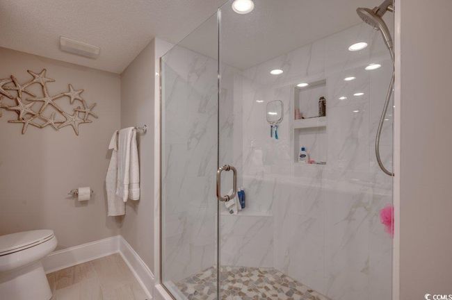 Bathroom with a textured ceiling, toilet, and an enclosed shower | Image 19