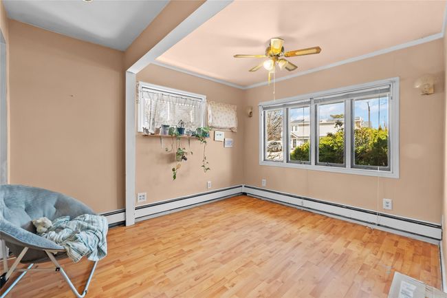 Unfurnished room with a baseboard radiator, a ceiling fan, crown molding, and wood finished floors | Image 7