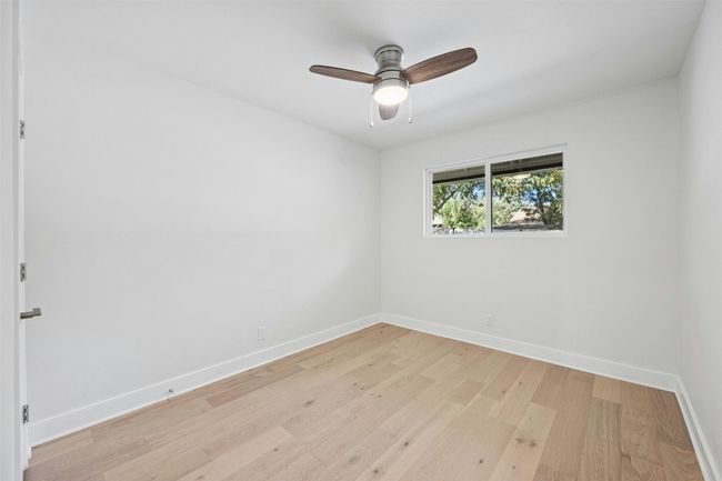Empty room with light wood-style flooring and a ceiling fan | Image 27
