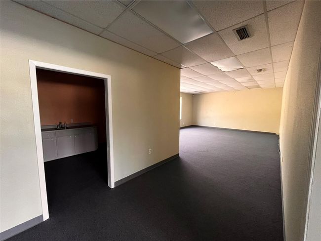 Empty room featuring baseboards, visible vents, a sink, and a paneled ceiling | Image 9
