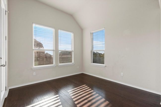 Empty room featuring dark wood-type flooring and vaulted ceiling | Image 15