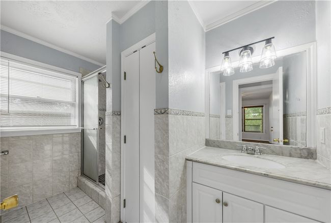 Bathroom featuring vanity, tile walls, and ornamental molding | Image 18
