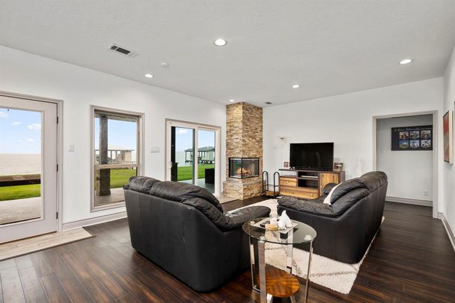 Family Room features a unique corner fireplace, large windows & sliding glass door entrance to back over-sized back patio. | Image 10