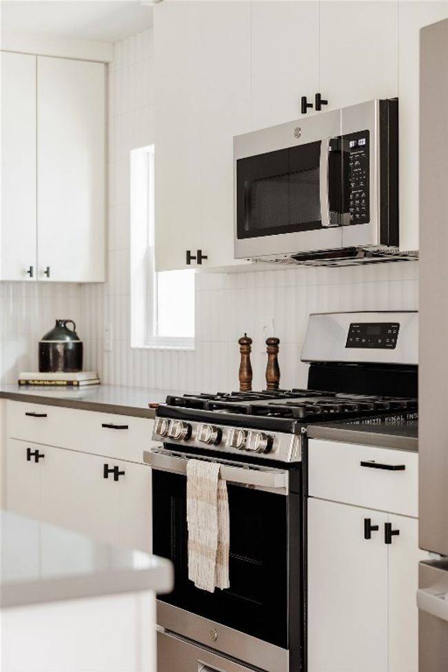 Kitchen with stainless steel appliances, tasteful backsplash, and white cabinetry | Image 12
