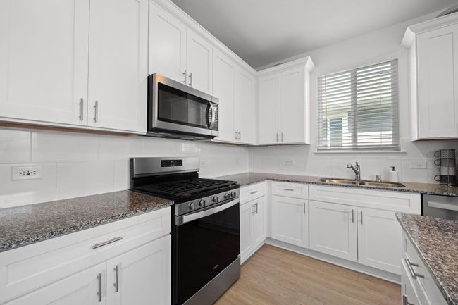 Equipped with a 5-burner gas range and sleek granite countertops, the kitchen blends performance with style. | Image 11