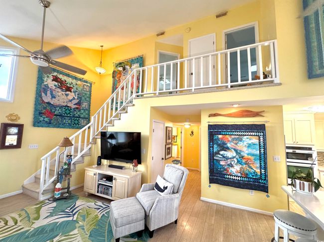 Living area with ceiling fan, stairs, light wood-style flooring, and a high ceiling | Image 21