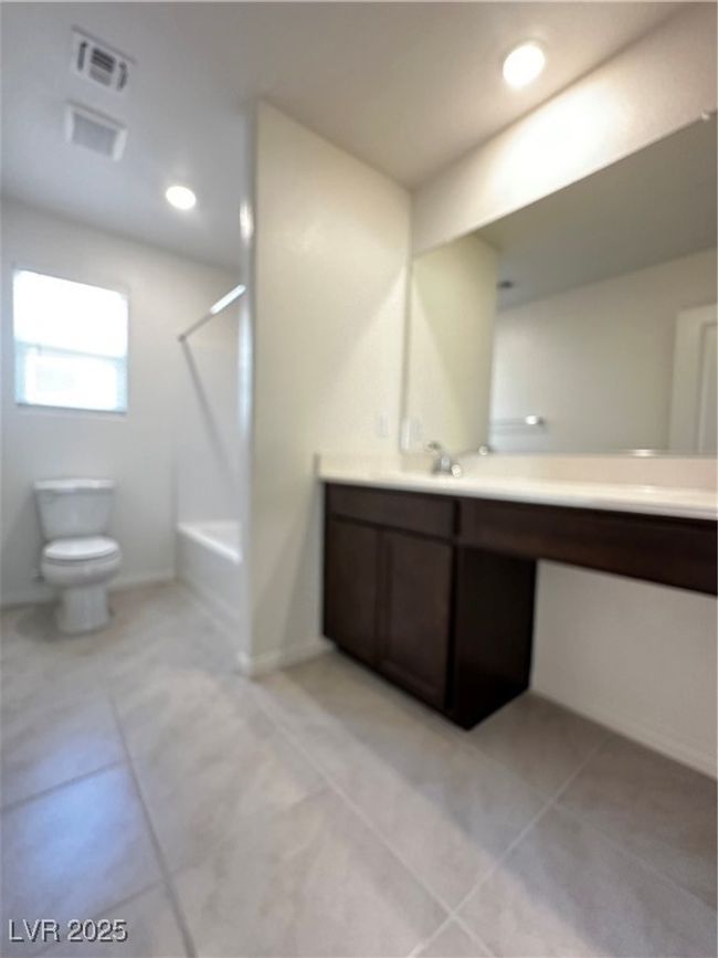 Full bathroom with toilet, vanity, tile patterned flooring, and visible vents | Image 13