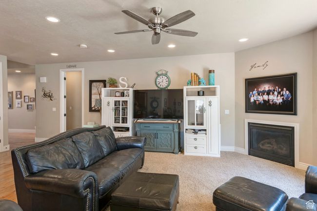 Living room featuring a glass covered fireplace, recessed lighting, and a ceiling fan | Image 6