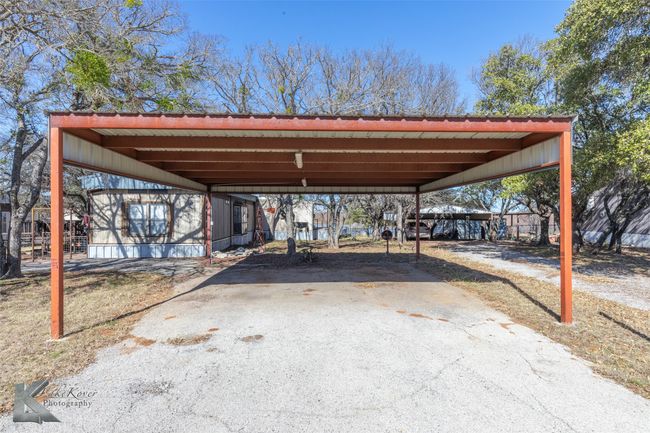View of vehicle parking featuring a detached carport and aphalt driveway | Image 4