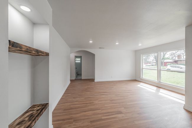 Spare room featuring arched walkways, light wood finished floors, recessed lighting, and baseboards | Image 31