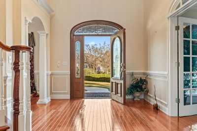 Foyer with light hardwood / wood-style flooring and decorative columns | Image 2