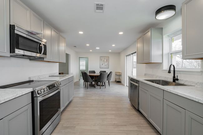 Kitchen featuring appliances with stainless steel finishes, gray cabinetry, and recessed lighting | Image 13