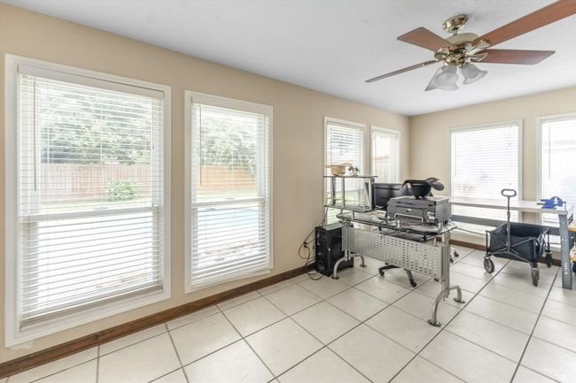 Sunroom/Office space with a ceiling fan, baseboards, and light tile patterned floors | Image 11