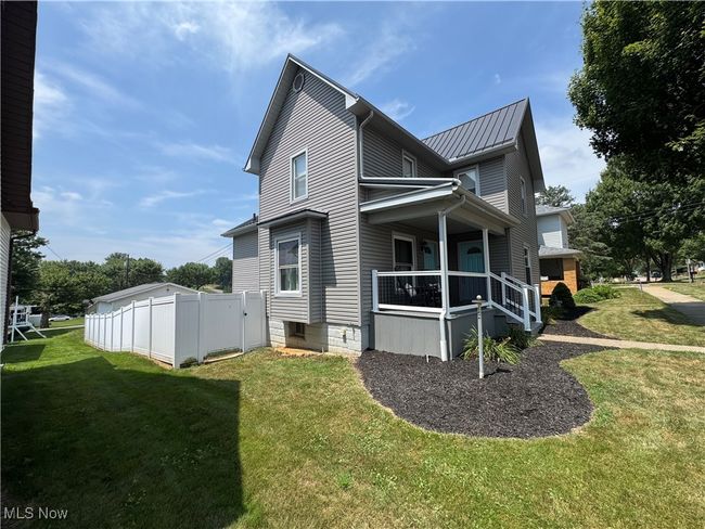 Side of property featuring covered porch and a metal roof | Image 4