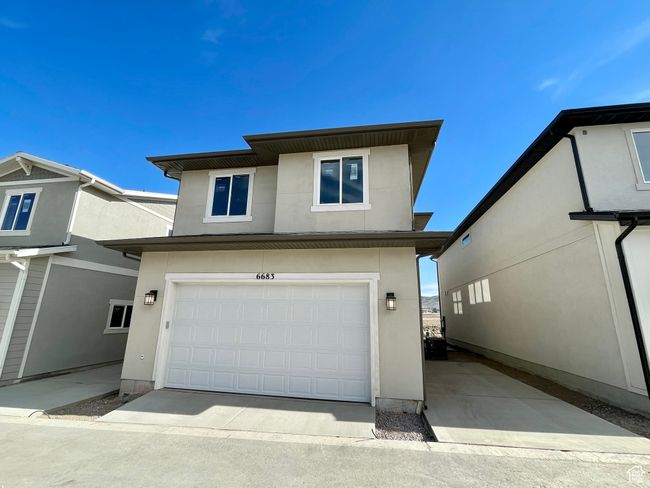 View of front of house featuring stucco siding, a garage, and concrete driveway | Image 20