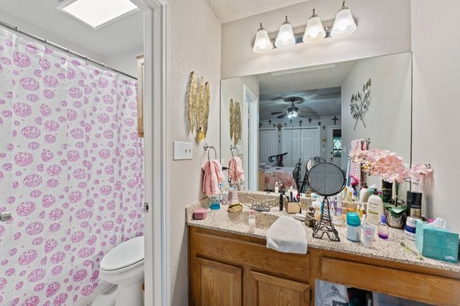Full bathroom featuring vanity, a ceiling fan, and a shower with curtain | Image 11