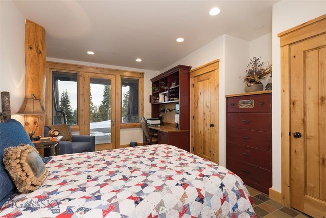 Entry level Bedroom 1 with custom built-in bookshelves, desk and dresser, with access to outside patio seating. | Image 49