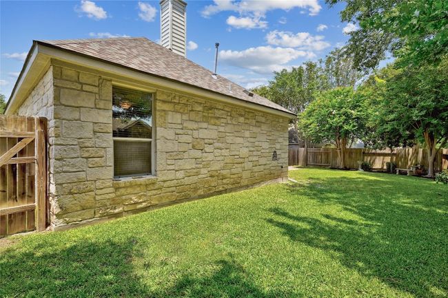 View of home's exterior featuring stone siding and a chimney | Image 30