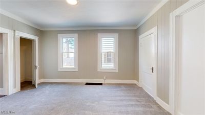 Unfurnished bedroom with light carpet and crown molding | Image 3