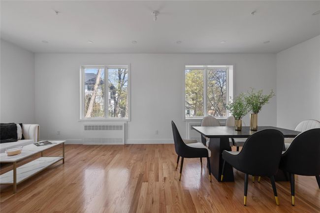 Dining area featuring baseboards, radiator heating unit, light wood-type flooring, and plenty of natural light | Image 18