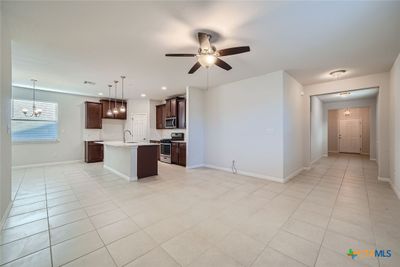 The open-concept living area boasts high ceilings and neutral walls, creating a bright and airy atmosphere for everyday living. | Image 2