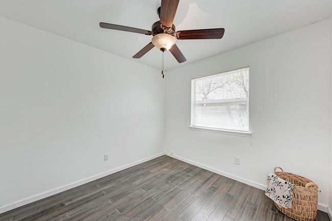 Unfurnished room featuring dark wood-type flooring, baseboards, and ceiling fan | Image 21