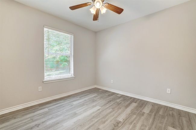 side facing window view, guest bedroom with light wood-style floors and ceiling fan | Image 24
